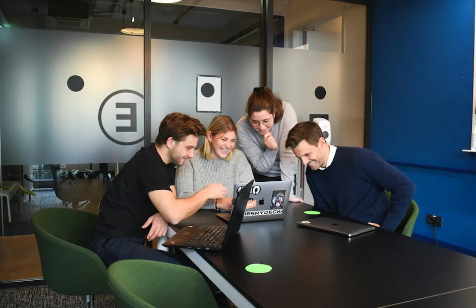 People sitting on chair in front of laptop computers.