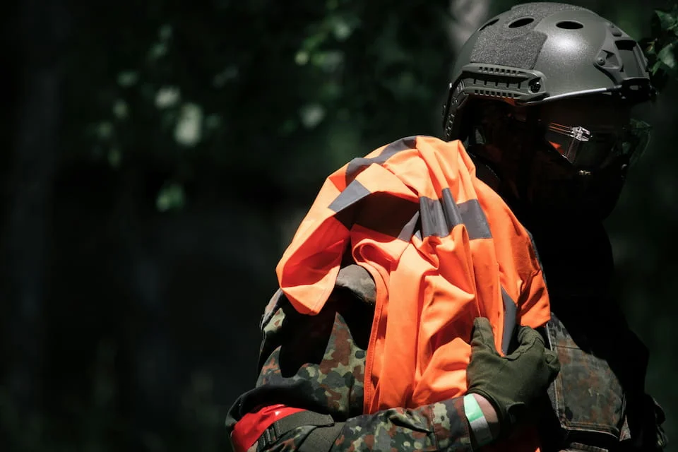 A man wearing an orange-and-black helmet and a black helmet.